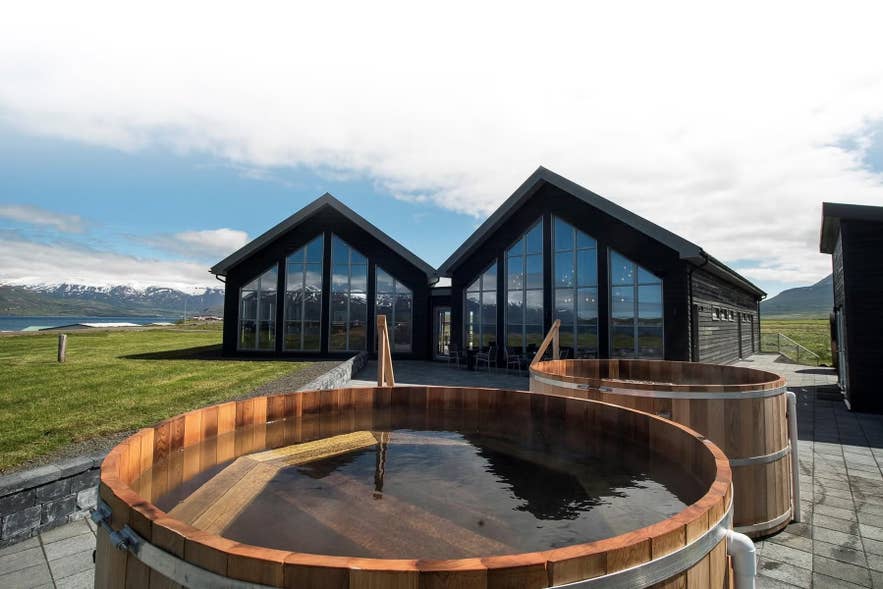 Hot tubs at Beer Bath near Akureyri, Iceland, with lodge views of snowy mountains and green fields. Hot tubs at Beer Bath near Akureyri, Iceland, with lodge views of snowy mountains and green fields.