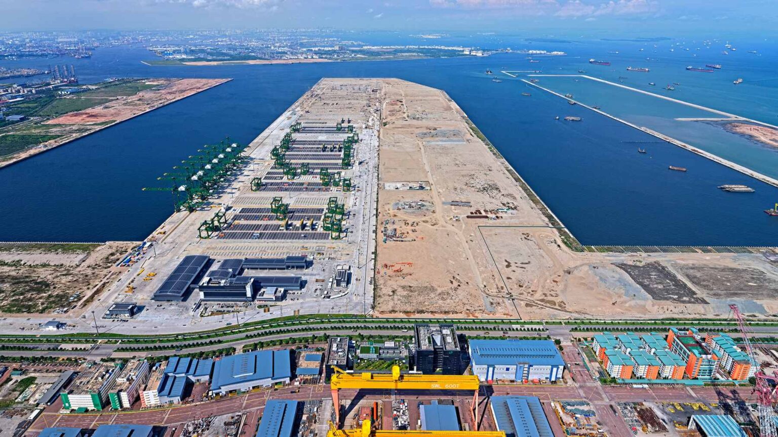 Massive concrete caissons being lowered into the sea to form the foundation of Singapore's automated Tuas Port expansion.