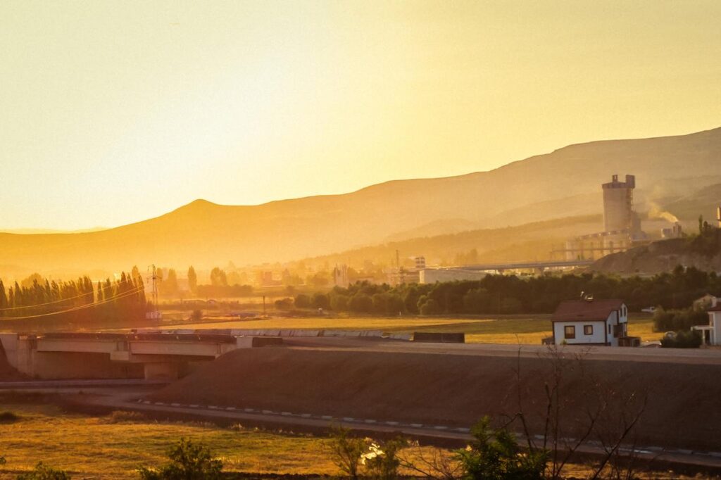 An industrial area and residential buildings are seen at sunset in a valley surrounded by mountains in Türkiye. (Adobe Stock Photo)