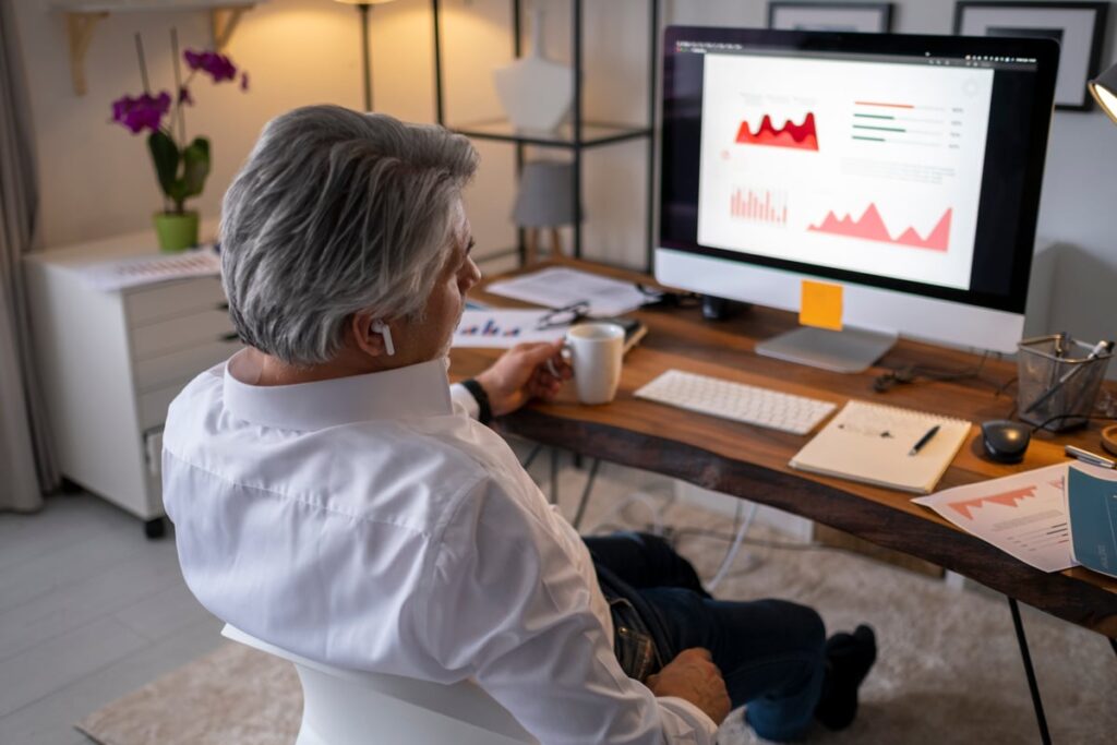 A marketing individual looks at charts on a computer screen.