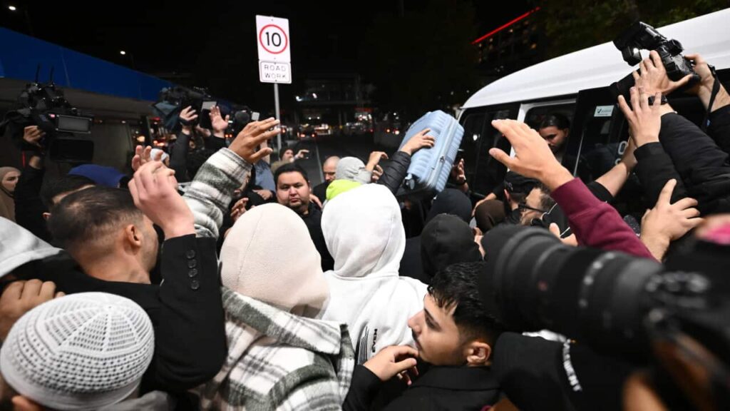 IS-linked woman attempted to board fight to Australia despite travel ban Three women move through a large crowd of people.