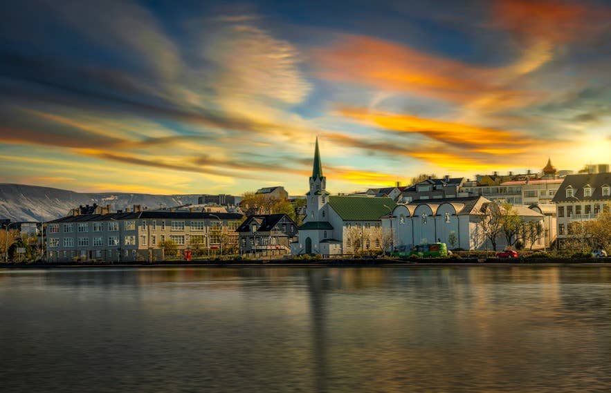 Tjornin Pond in Reykjavik on a calm day, with a colorful sunset