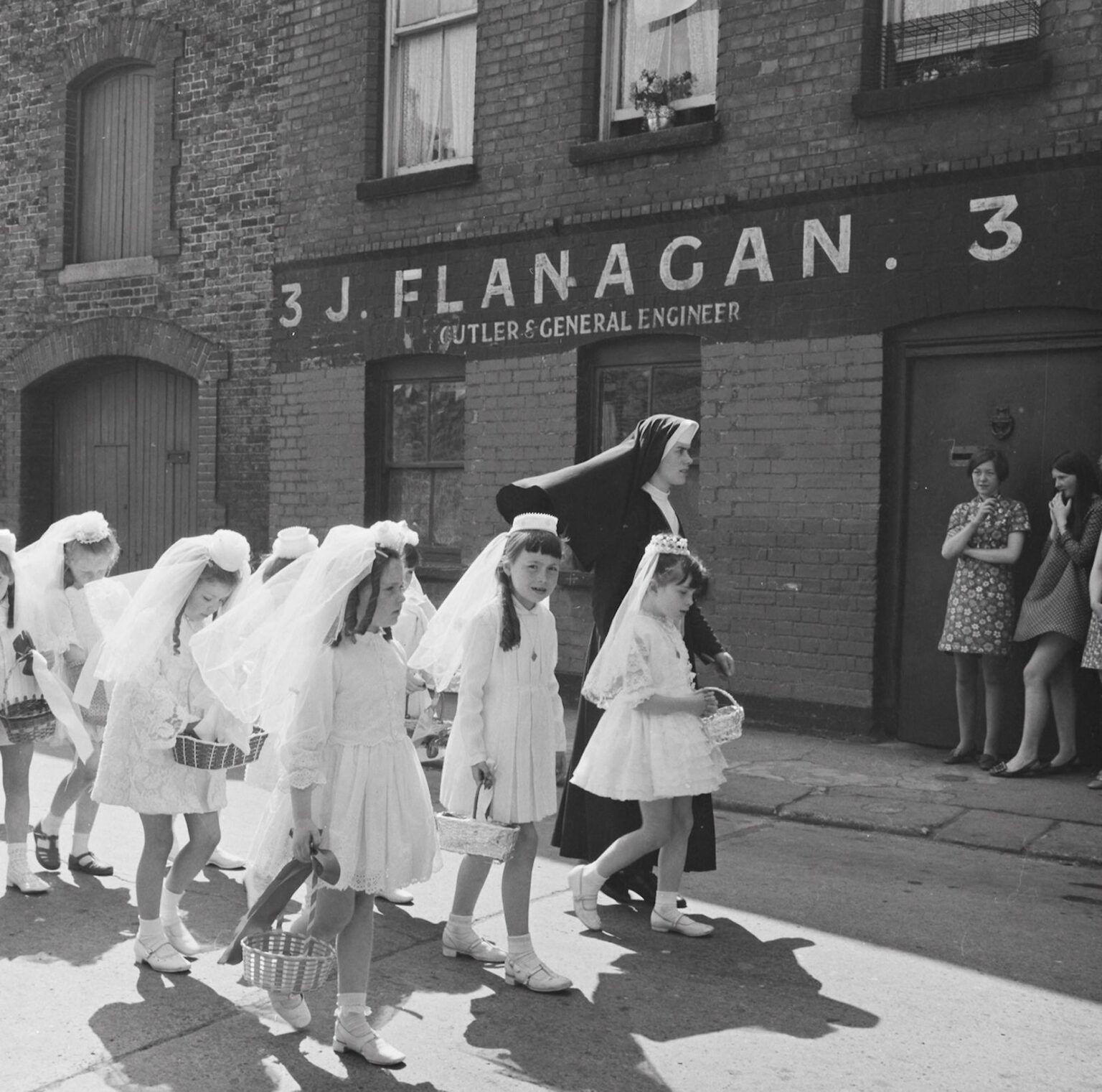 A nun walking a group of girls to their Holy Communion in Dublin. (1969)