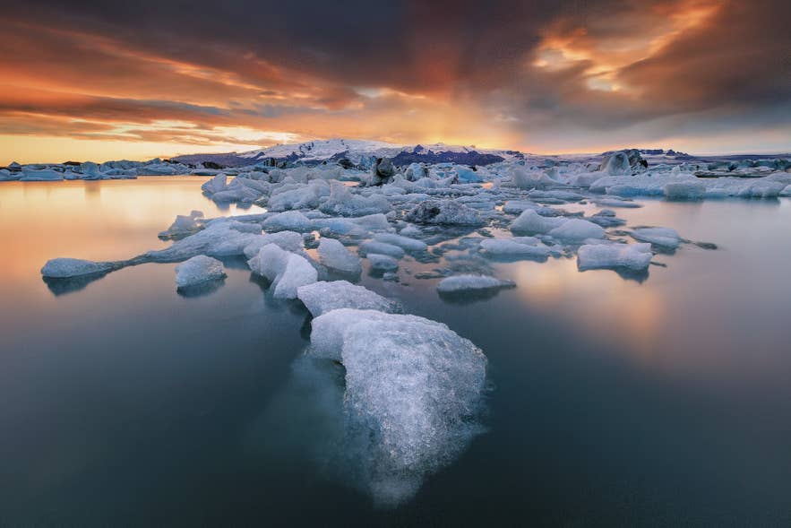 Icebergs floating at Jokulsarlon Glacier Lagoon near Vatnajokull, highlighting cold conditions that shape what to wear in Iceland. Icebergs floating at Jokulsarlon Glacier Lagoon near Vatnajokull, highlighting cold conditions that shape what to wear in Iceland.