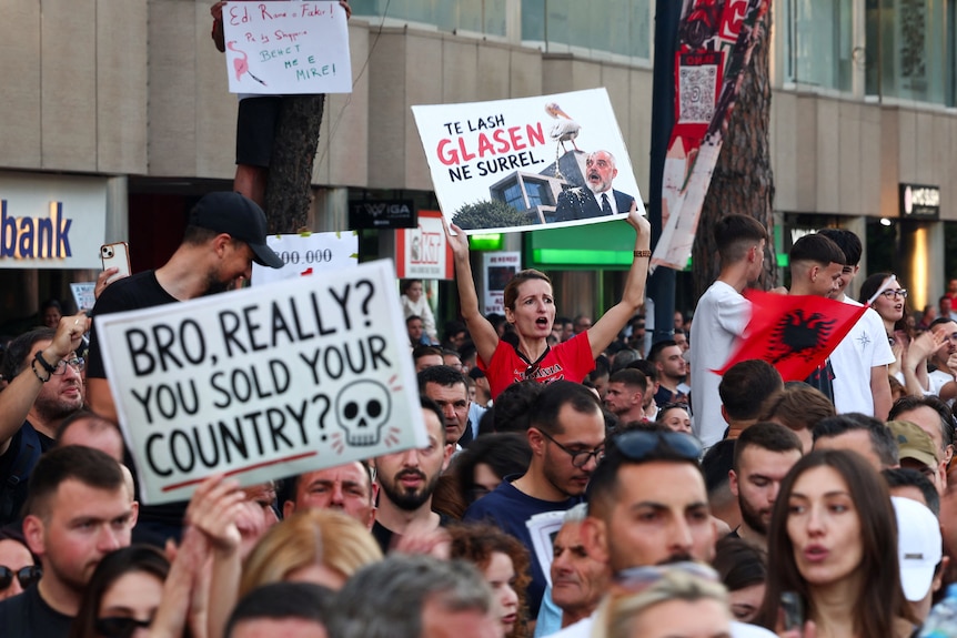Protesters hold up signs incluing 'Bro really? You sold your country?'