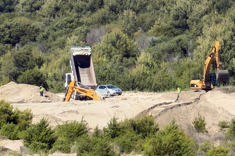 A excavator is seen among sand.