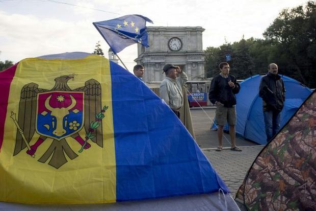 Men stand next to tents set up by protesters in Chisinau on September 7  2015