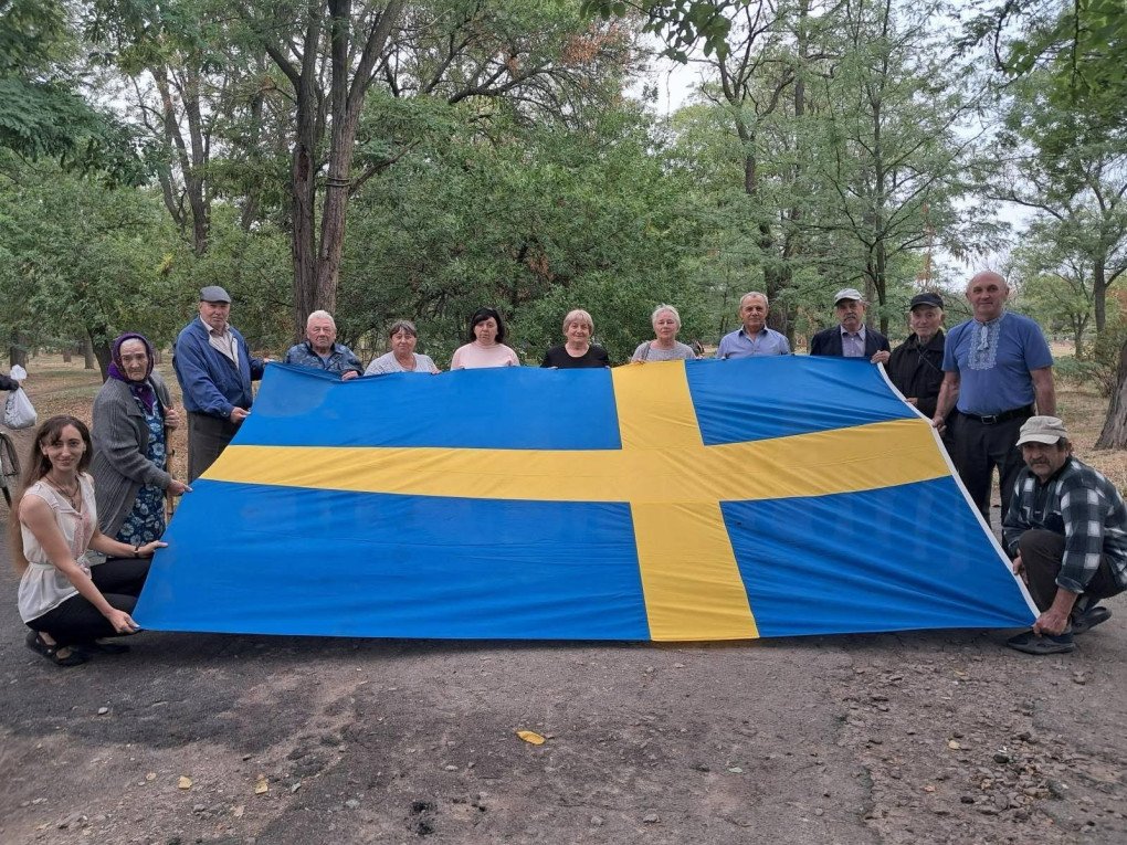 Residents of Zmiivka pose with a Swedish flag gifted by the King of Sweden in 2008. The flag was preserved by the village mayor during the eight-month Russian occupation. ((Photo: Facebook/ Svitlana Zalishchuk) Residents of Zmiivka pose with a Swedish flag gifted by the King of Sweden in 2008. The flag was preserved by the village mayor during the eight-month Russian occupation. ((Photo: Facebook/ Svitlana Zalishchuk)