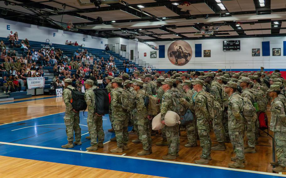 Soldiers standing in a gymnasium.