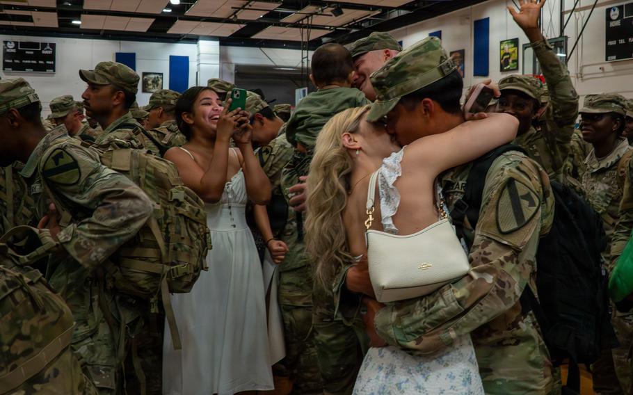 A couple reunites and kiss.