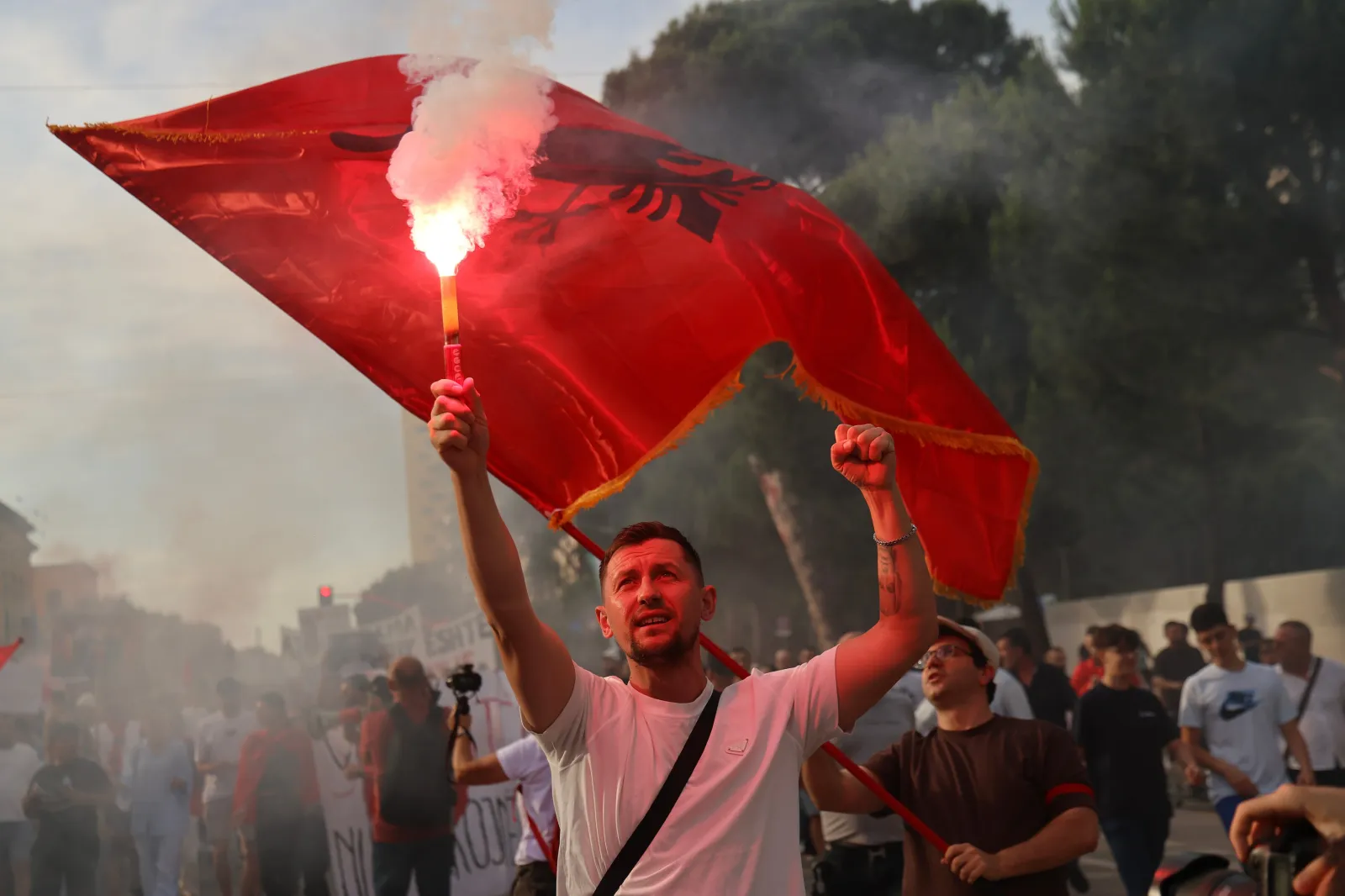 A protester raises a flare during a rally in Tirana, Saturday, June 6, 2026, against the construction of a massive coastal development project linked to Jared Kushner and Ivanka Trump at Narta lagoon area, western Albania.