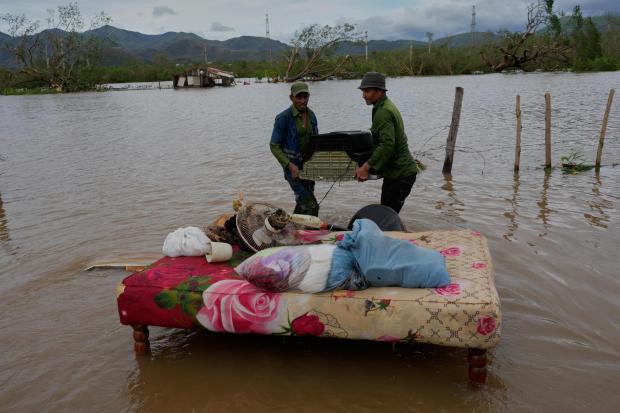 FILE - People recover belongings from a home flooded by Hurricane Melissa in Santiago de Cuba, Oct. 29, 2025. (AP Photo/Ramón Espinosa, File)