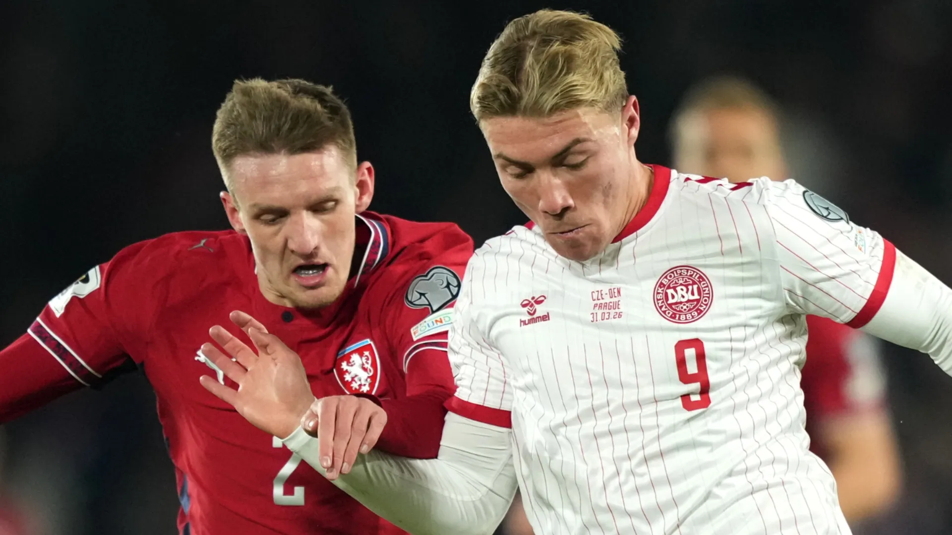 Rasmus Hojlund of Denmark runs with the ball under pressure from Stepan Chaloupek of Czechia.