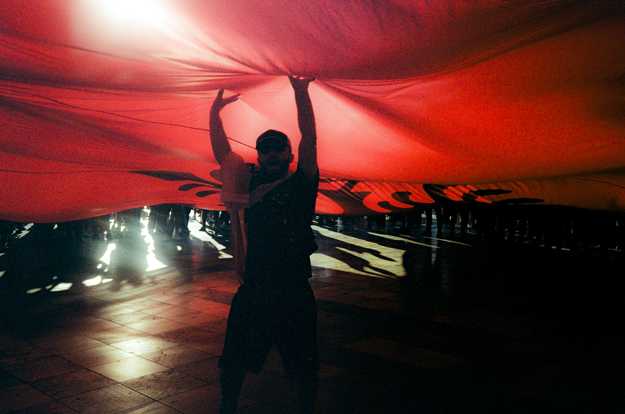 Man under a very large Albanian flag.
