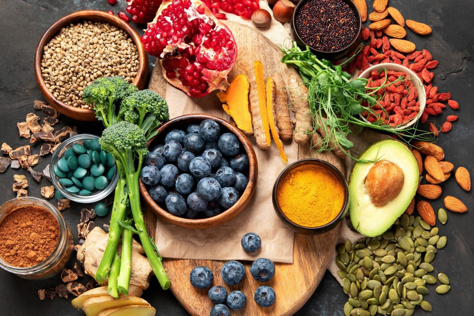 Dietary guidelines miss key flavanol levels for heart health high flavanol food selection including blueberries, and brocolli on dark background. Superfood assortment. Top view,.