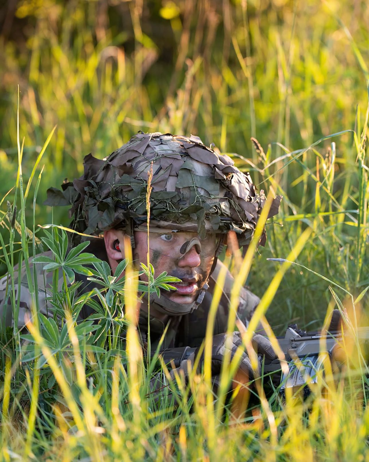 Image may contain Photography Person Taking Cover Face Head Portrait Clothing Hat Gun and Weapon