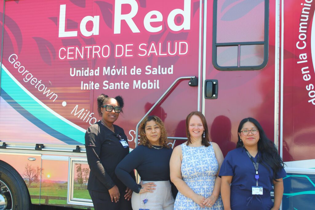 Women stand in front of the La Red Health Center's mobile unit