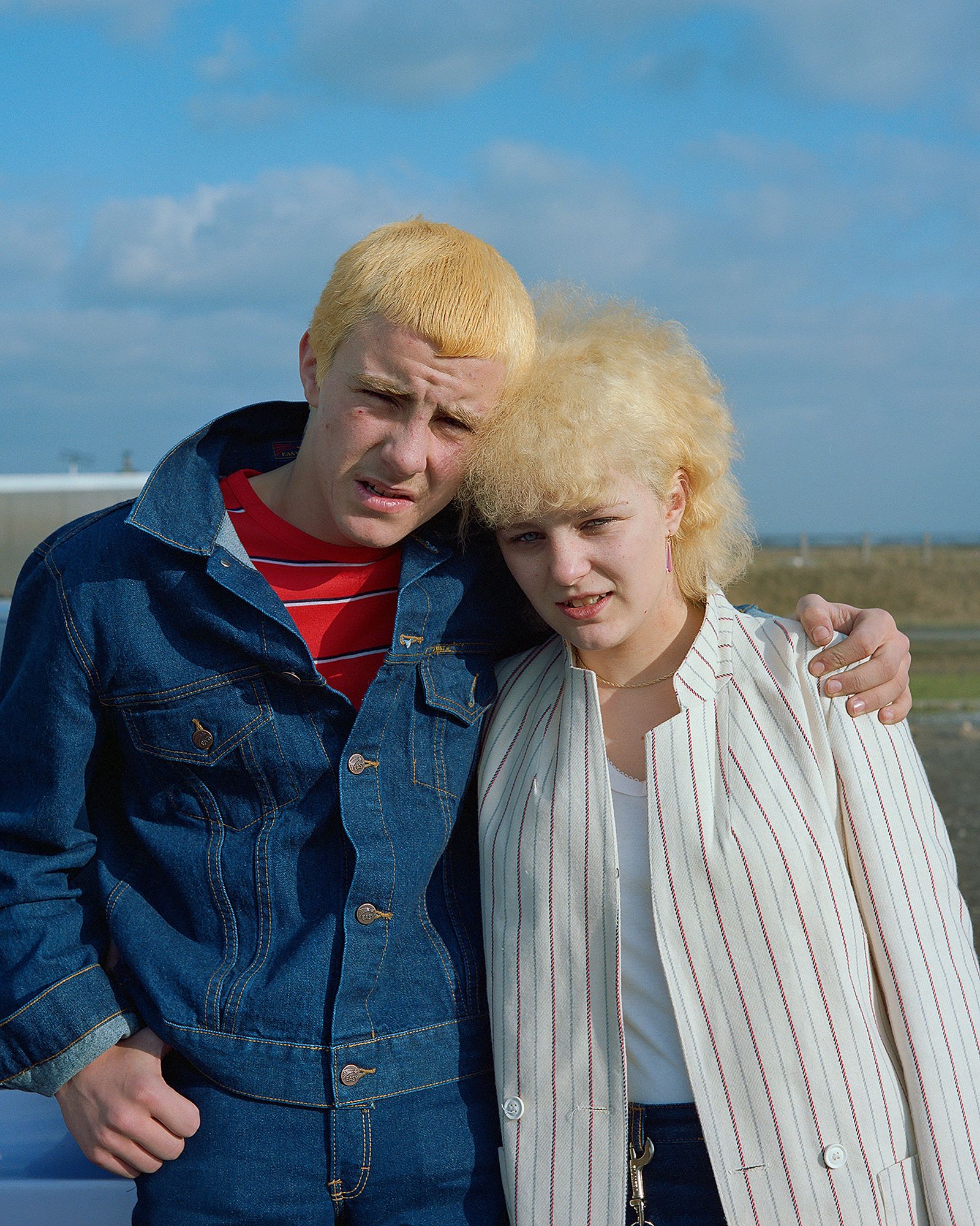 A young man and woman both with bleached blonde hair.