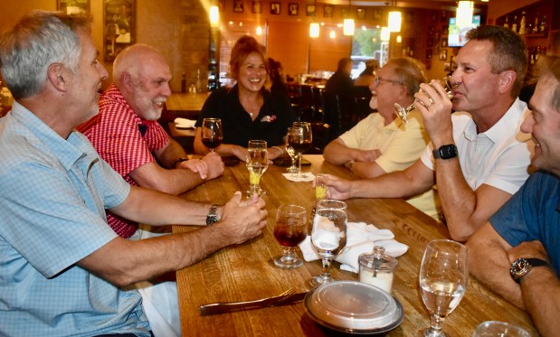 Trinette Angeli visits with patrons at Angeli's, the Italian restaurant she and husband Tony own in Naperville. Chris Hall, from left, Eddie Murphy, Bill Windisch, John Zubak and Randy Laible are frequent visitors. (Steve Metsch/Naperville Sun)