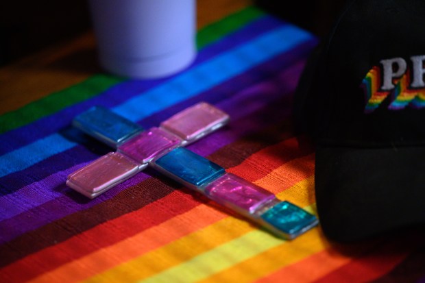 A tile cross made with the colors of the transgender pride flag sits near the altar during an annual ceremony for Transgender Day of Remembrance at Metropolitan Community Church in Portage on Thursday, November 20, 2025. (Kyle Telechan/for the Post-Tribune)