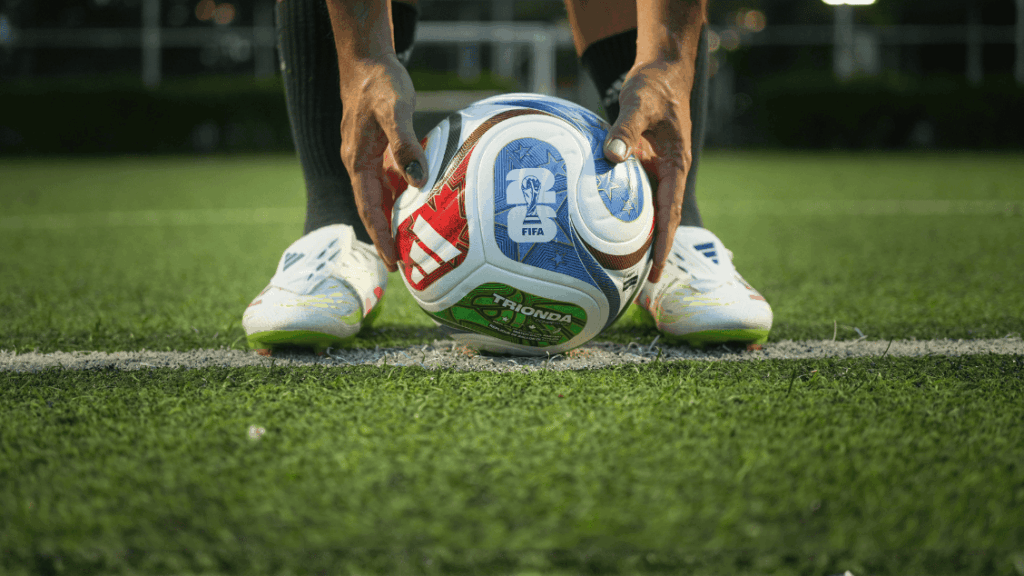 Soccer ball positioned on a green field, ready for play, with a focus on sports finance and global s.