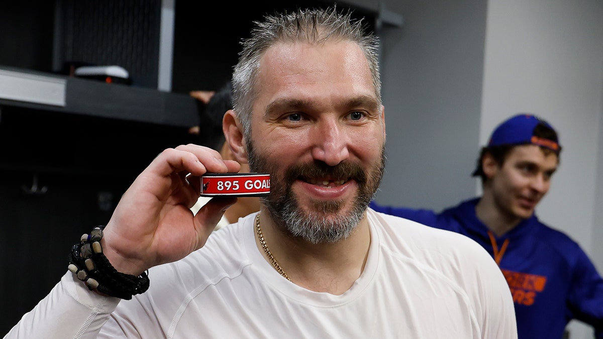 Alex Ovechkin poses with puck celebrating goal at UBS Arena