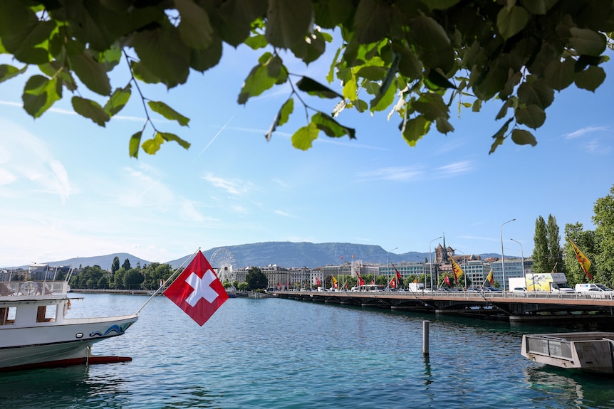 A Swiss flag in front of the Mont-Blanc bridge in Geneva