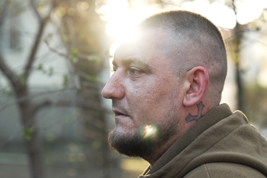 The side profile of Yaroslav wearing a green hoodie.