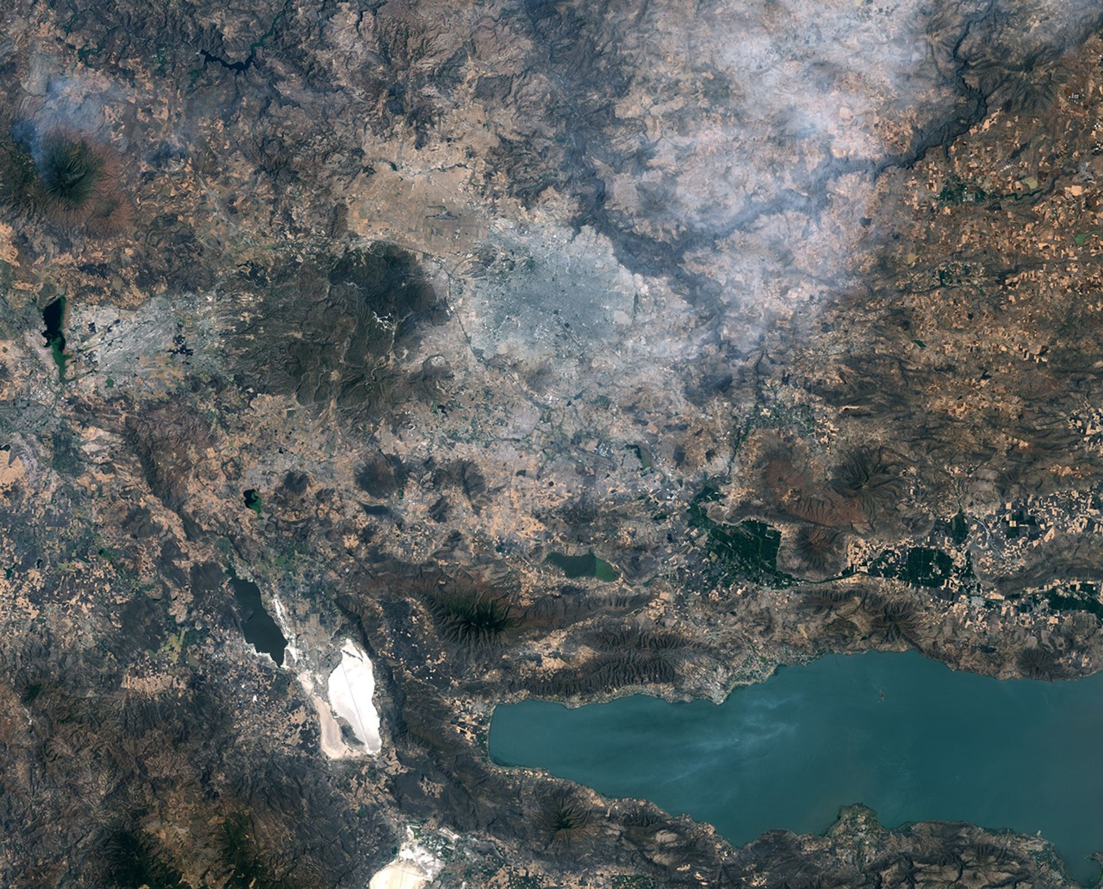 Images of Guadalajara in 1986 (left) and 2026 (right) shows the city expanding westward into an area that had been mostly farmland. Guadalajara Stadium appears as a small circular feature on the left side of the 2026 image.