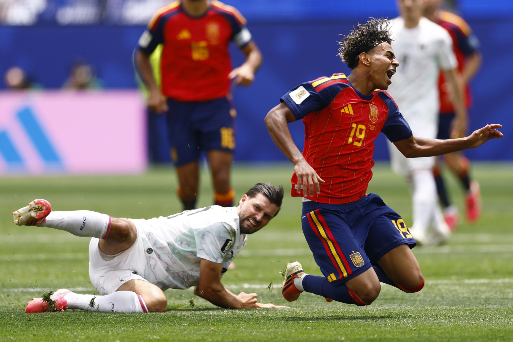 Spain forward Lamine Yamal falls after Austria midfielder Florian Grillitsch kicks the ball away.