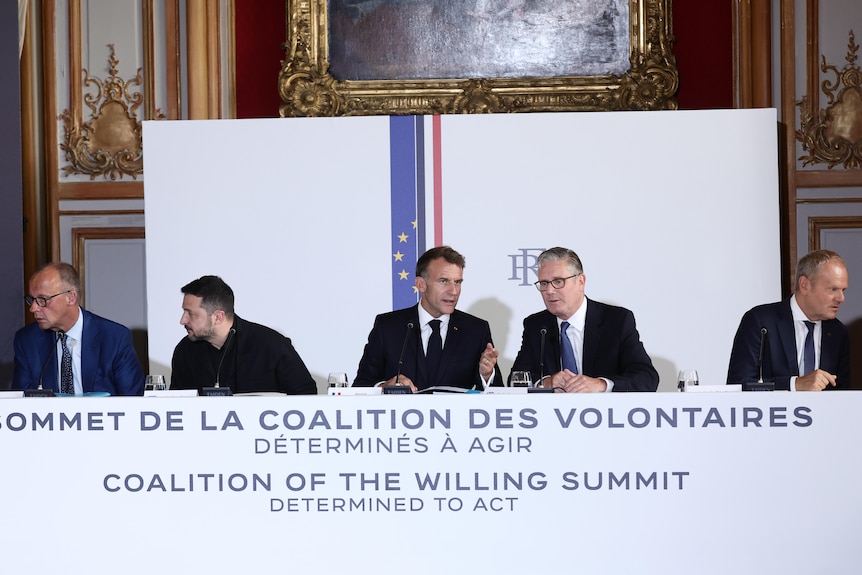 A group of male poiticians in suits at a meeting
