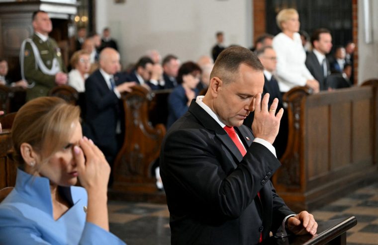Poland's new President Karol Nawrocki (R) and his wife Marta Nawrocka make the sign of the cross during a mass at St John's Archcathedral on August 6, 2025 in Warsaw, after Nawrocki was sworn in. Poland's new nationalist president Karol Nawrocki called for a "sovereign Poland" and promised to "fight those who are pushing the nation towards decline". Nawrocki, 42, a supporter of US President Donald Trump, won a June 1, 2025 election in a major blow for the pro-EU government of Prime Minister Donald Tusk, a former European Council president. (Photo by Sergei GAPON / AFP) (Photo by SERGEI GAPON/AFP via Getty Images)