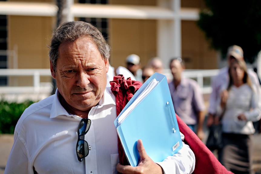 A man, looking serious, leaving court.