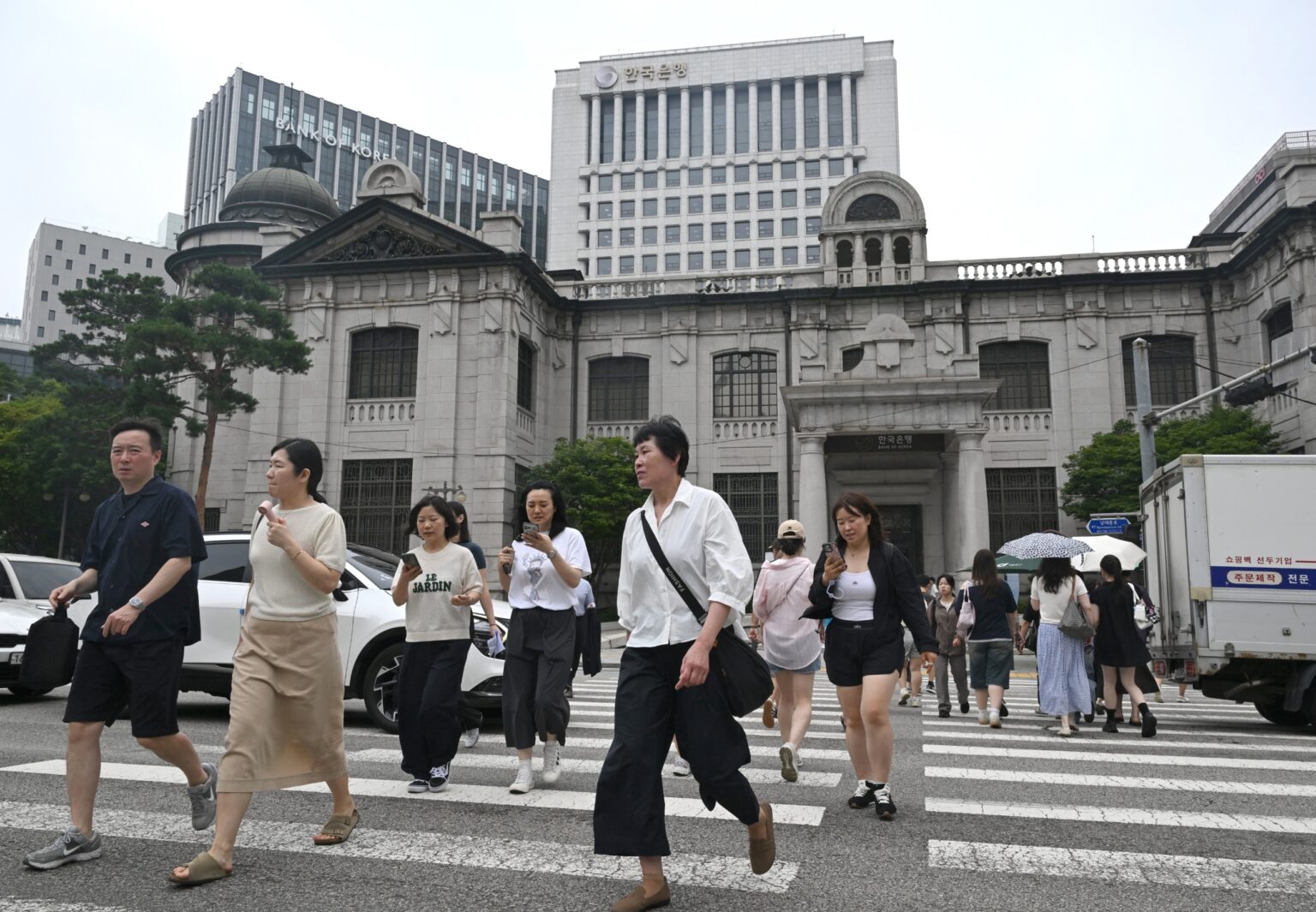 Bank of Korea Ends Three-Year Rate Freeze as AI Chip Boom Stokes Inflation Pedestrians cross road front Bank Korea headquarters