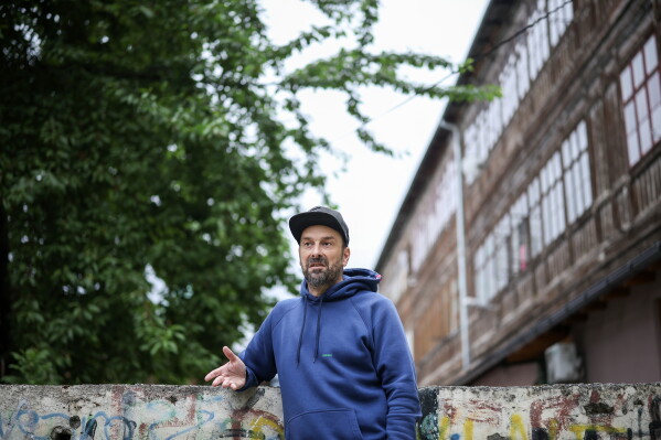 Brano Jakubovic, a member of Bosnian band Dubioza kolektiv, speaks during an interview for The Associated Press at a soccer playground where the video for the song "I Am From Bosnia, Take Me to America" was filmed, in Sarajevo, Bosnia, Thursday, June 11, 2026. (AP Photo/Armin Durgut)