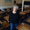 Ramona Klein poses for a photo in a classroom at the former Fort Totten Indian Industrial School in North Dakota. Klein attended the boarding school from 1954 to 1958.