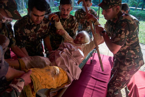 An elderly survivor is taken to a makeshift hospital for treatment at the army's Maithali barracks after being rescued from flash flooding in Nuwakot district, Nepal, Thursday, Aug. 27, 2026. (AP Photo/Niranjan Shrestha)