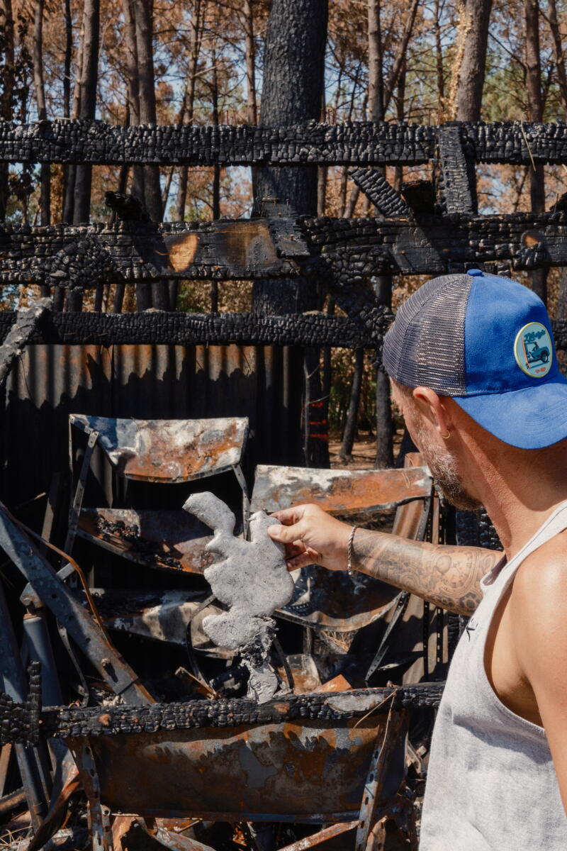 a man hold up a piece of metal that melted in a fire