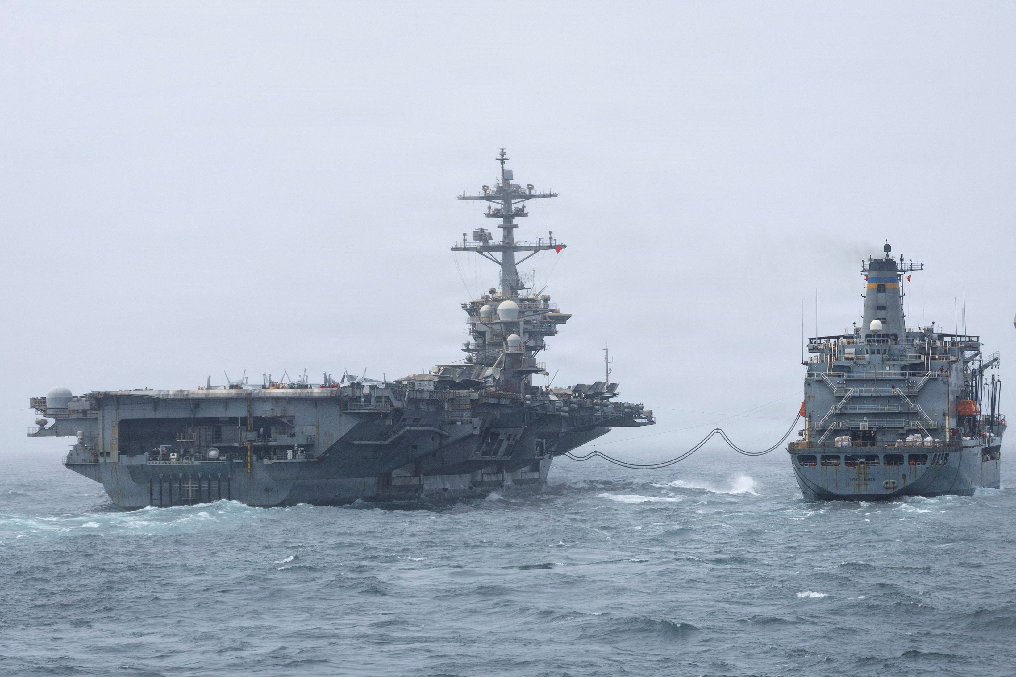 The USS Abraham Lincoln, left, is steaming home to the U.S. after completing a record deployment to the Middle East