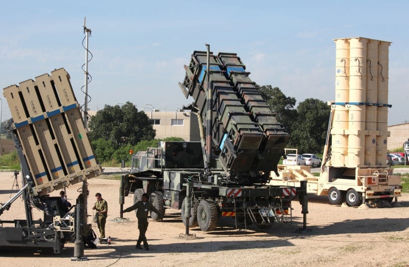 Israeli soldiers walk near an Israeli Irone Dome defence system (L), a surface-to-air missile (SAM) system, the MIM-104 Patriot (C), and an anti-ballistic missile the Arrow 3 (R) during Juniper Cobra's joint exercise press briefing at Hatzor Israeli Air Force Basel, on February 25, 2026.