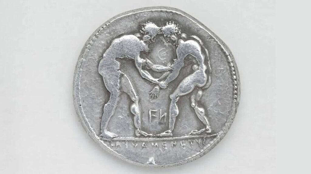 Ancient Greek coin depicting two wrestlers fighting in the arena.