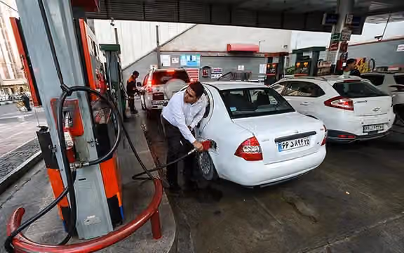 File photo shows a man filling his car with gasoline at a gas station in Tehran. (undated)