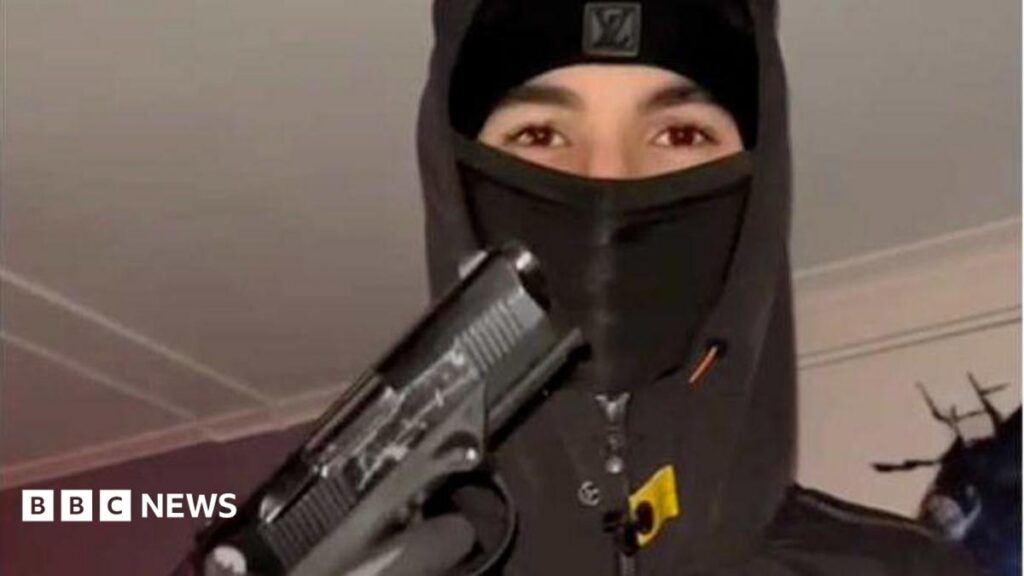 Foxtrot Network: The shadowy gang recruiting teen killers across Europe A teenager wearing a black balaclava and hoodie holding up a handgun, with his gloved hand on the trigger