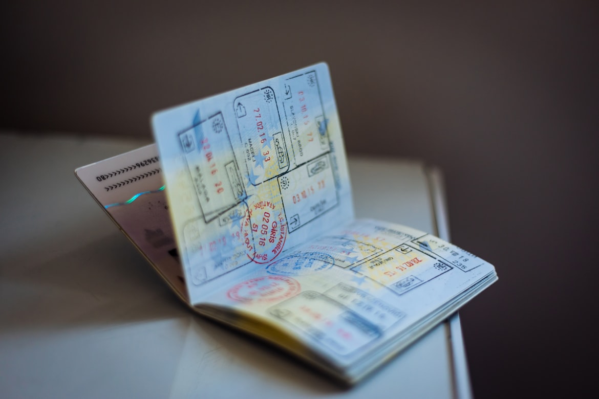 Open passport with multiple colorful entry and exit stamps resting on a table