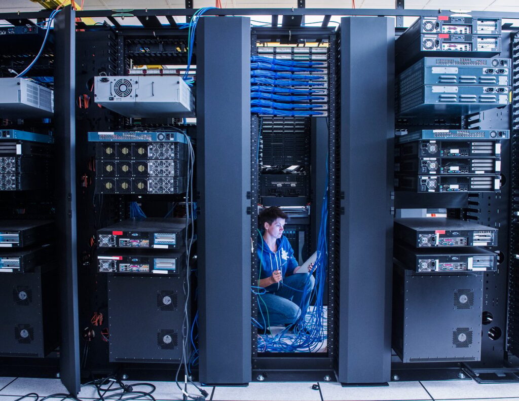 Broadcom vs. Nvidia: 1 Metric Shows Which Artificial Intelligence (AI) Chipmaker Is the Better Bargain Tech working on computing equipment in a data center.