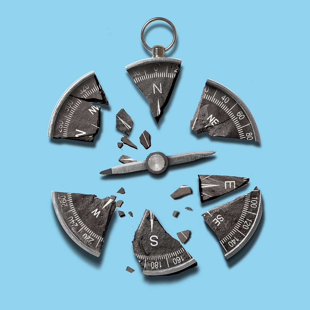 A dark gray vintage compass broken into several sharp fragments, arranged in a circle against a bright blue background. The needle sits detached in the center, surrounded by broken pieces displaying cardinal directions and degree markings. Image 4 (Alligators in Water)