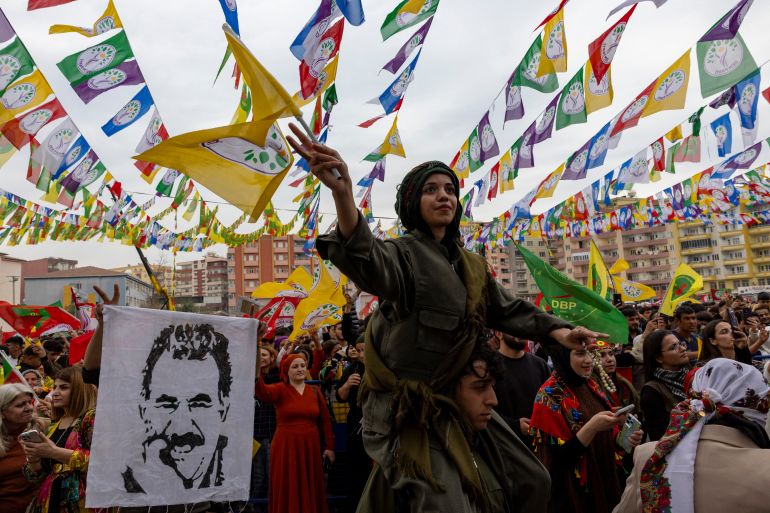 A man holds a flag with an image of jailed Kurdish leader Abdullah Ocalan as people gather to celebrate spring festival of Newroz in the southeastern town of Kiziltepe in Mardin province, Turkiye, March 18, 2025
