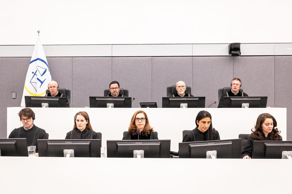 The ambiguities of the Kosovo Chambers The Kosovo Special Chambers (KSC), a UN international tribunal based in The Hague (Netherlands), has just handed down a verdict on four Kosovar figures charged with war crimes, including former President Hashim Thaçi. Photo: the four judges are seated on a platform above their five assistants in a very bright, cold white setting.