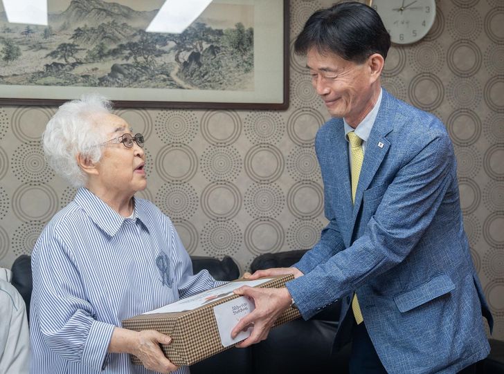 Park Jong-sul, right, secretary general of the Korean Red Cross, visits a separated family member in western Seoul who was forced to break from her relatives in North Korea during the 1950-53 Korean War, Sept. 15. Courtesy of Korean Red Cross