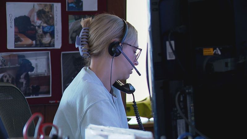 A dispatcher speaks on the phone at the Penobscot County Regional Communications Center (WGME)